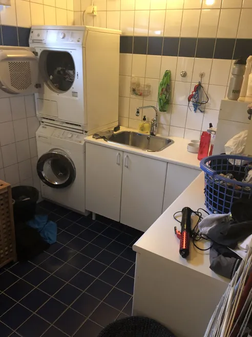Eldre vaskerom med vaskemaskin, tørketrommel og utslagsvask